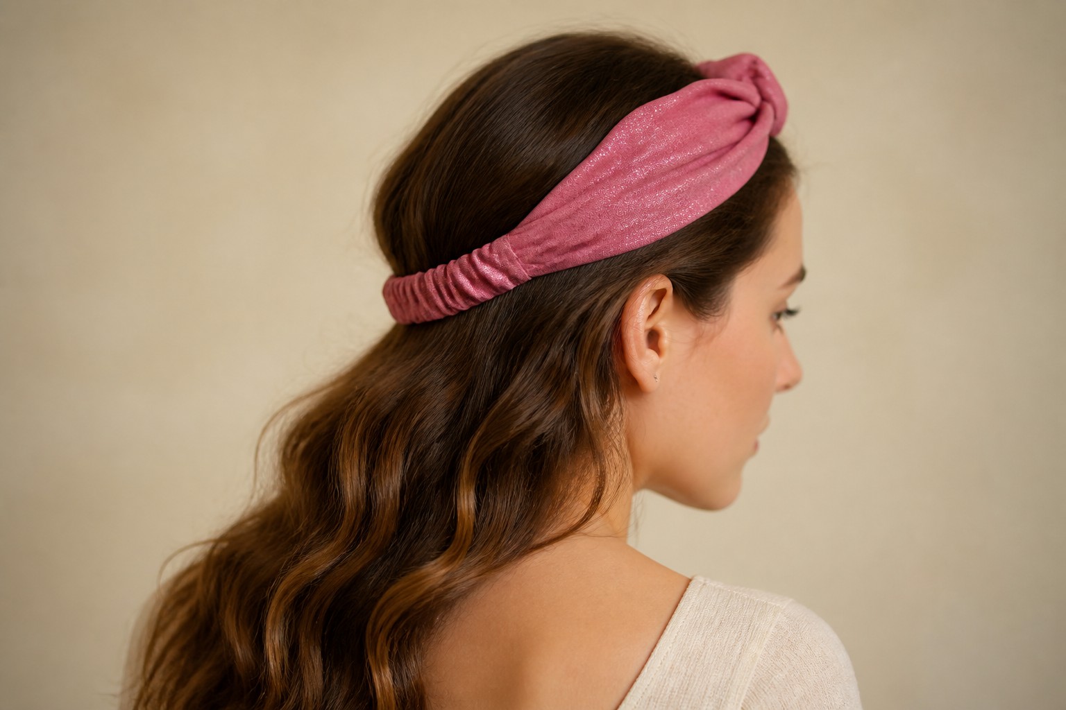Bandeau Aélia rose scintillant porté de profil, tempes libérées, studio